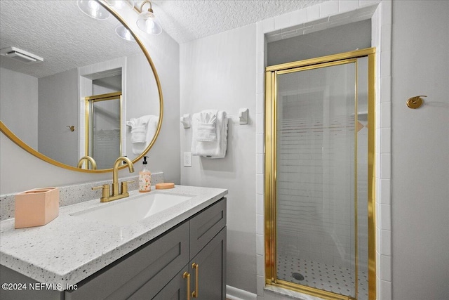 bathroom featuring vanity, a textured ceiling, and an enclosed shower