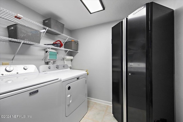 washroom featuring washing machine and clothes dryer and light tile patterned floors