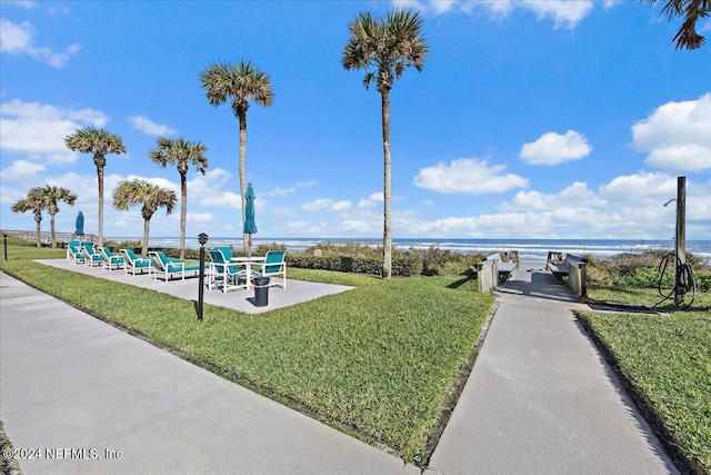 view of property's community with a lawn and a water view