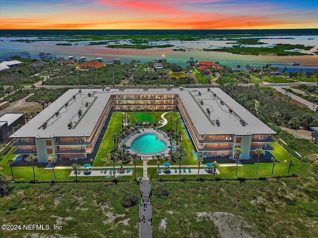 aerial view at dusk featuring a water view