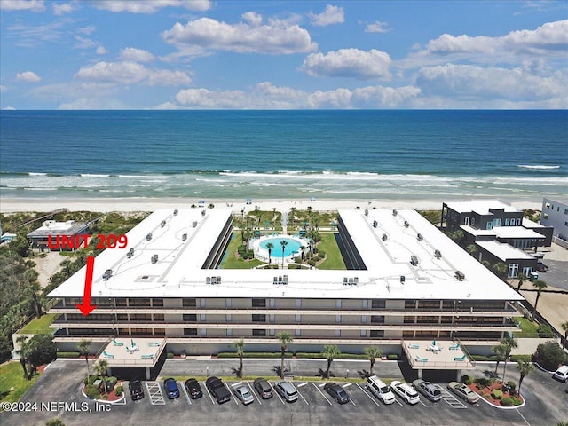 bird's eye view featuring a water view and a beach view