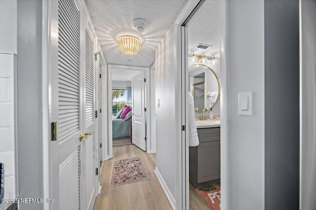 7870 A1A S Unit 209, Saint Augustine, FL 32080 - hallway with light wood-style floors, a chandelier, and baseboards