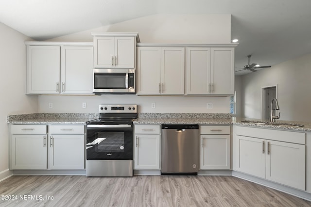 kitchen with white cabinetry, lofted ceiling, appliances with stainless steel finishes, and sink