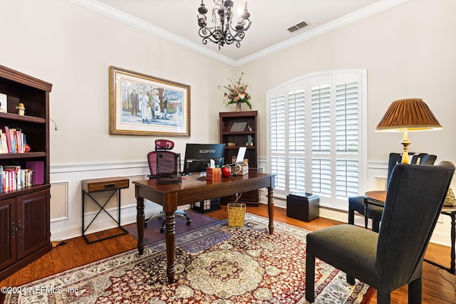 office space with a notable chandelier, wood finished floors, visible vents, and ornamental molding