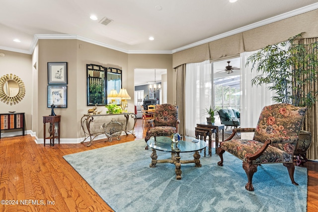 living area featuring a wealth of natural light, visible vents, crown molding, and wood finished floors