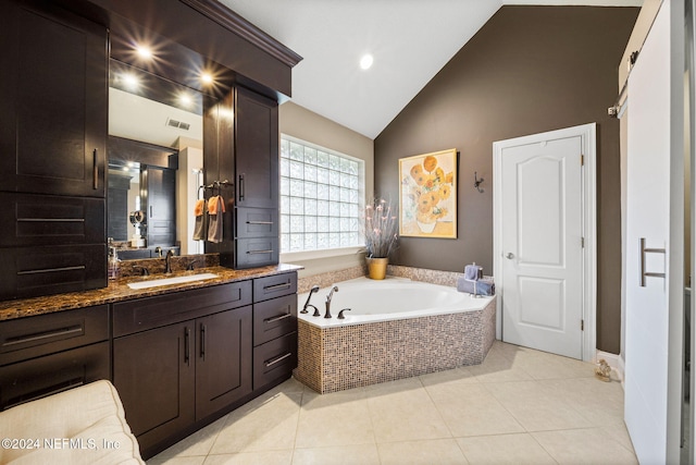 bathroom featuring tile patterned floors, visible vents, a garden tub, vanity, and vaulted ceiling