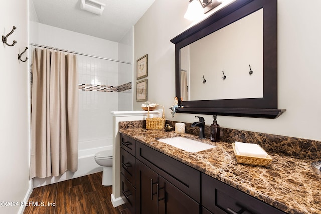 full bath with toilet, wood finished floors, vanity, and shower / bath combination with curtain