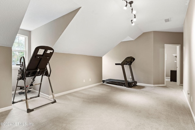 exercise room featuring vaulted ceiling, baseboards, and visible vents