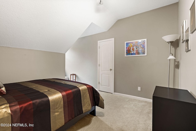 carpeted bedroom with baseboards, a textured ceiling, and vaulted ceiling