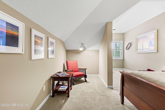 bedroom featuring vaulted ceiling, carpet flooring, baseboards, and a textured ceiling