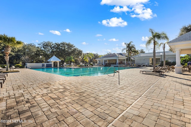 pool featuring fence and a patio area