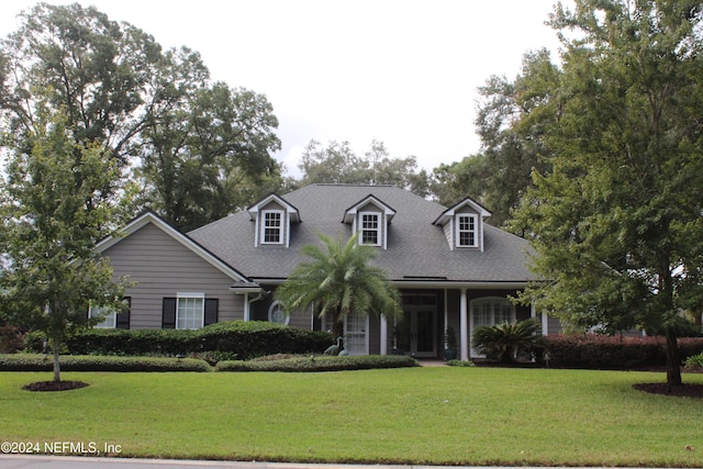 cape cod home with a front yard and a porch