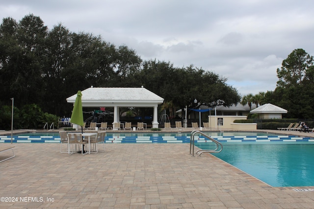 community pool featuring a gazebo, a patio, and fence