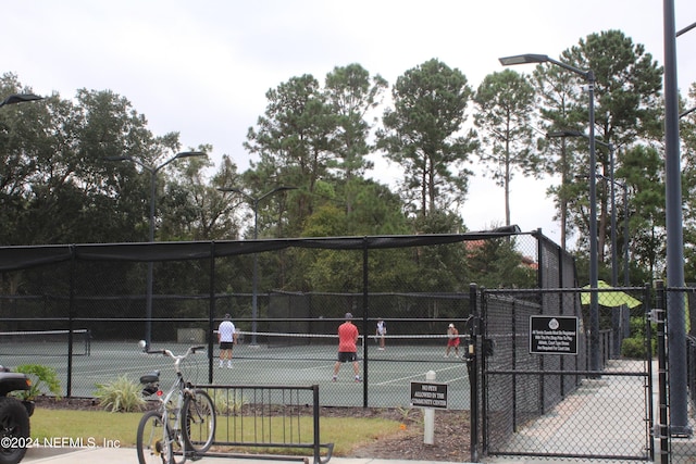 view of sport court with a gate and fence