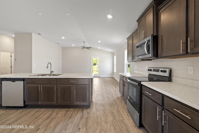 kitchen with sink, vaulted ceiling, ceiling fan, appliances with stainless steel finishes, and light hardwood / wood-style floors