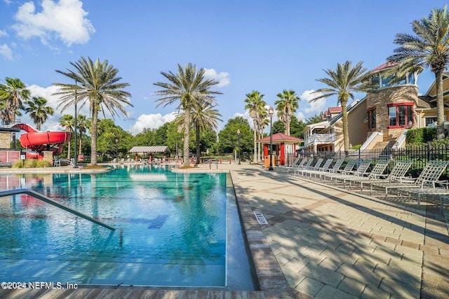 view of swimming pool with a patio and a water slide