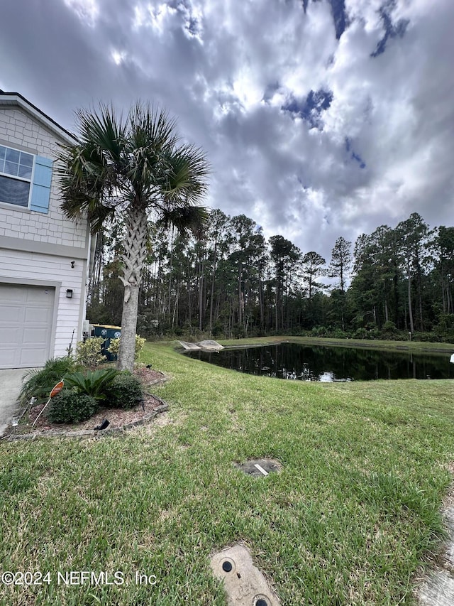 view of yard with a water view and a garage