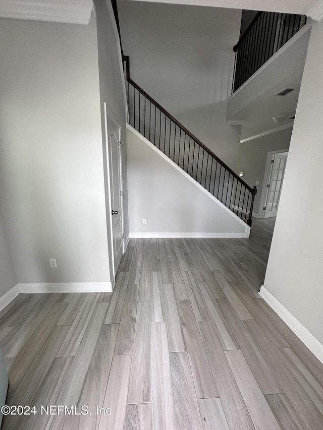 interior space featuring a towering ceiling and hardwood / wood-style flooring