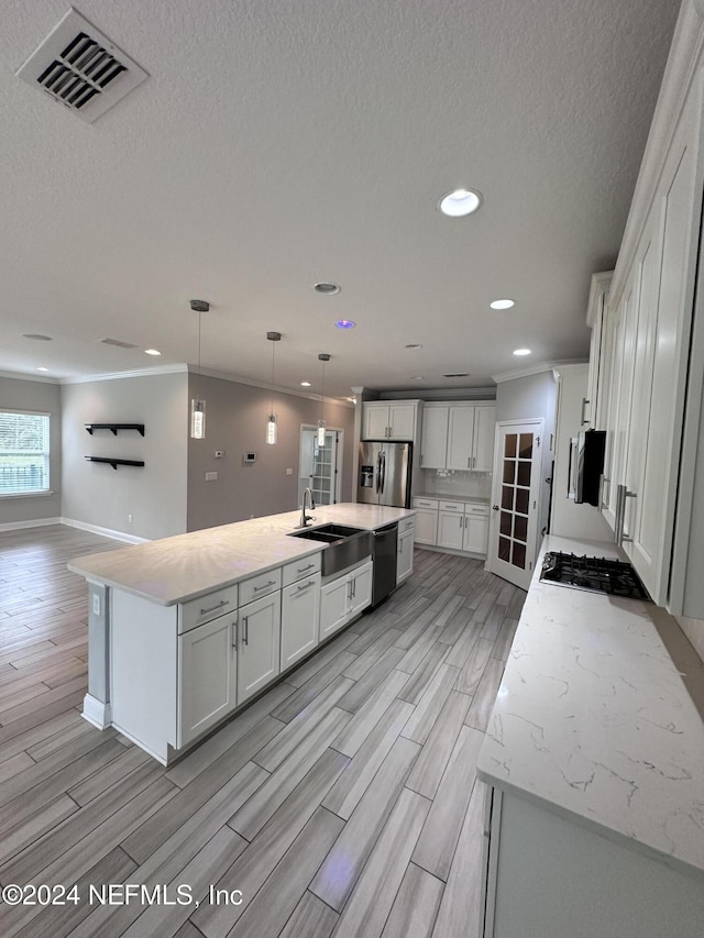 kitchen with white cabinetry, dishwasher, stainless steel fridge with ice dispenser, light hardwood / wood-style flooring, and a kitchen island with sink