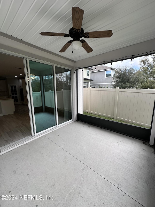 unfurnished sunroom with ceiling fan