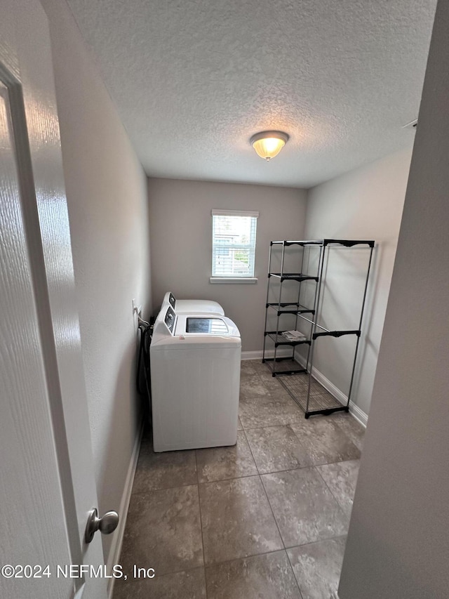 laundry room featuring light tile patterned flooring, a textured ceiling, and independent washer and dryer