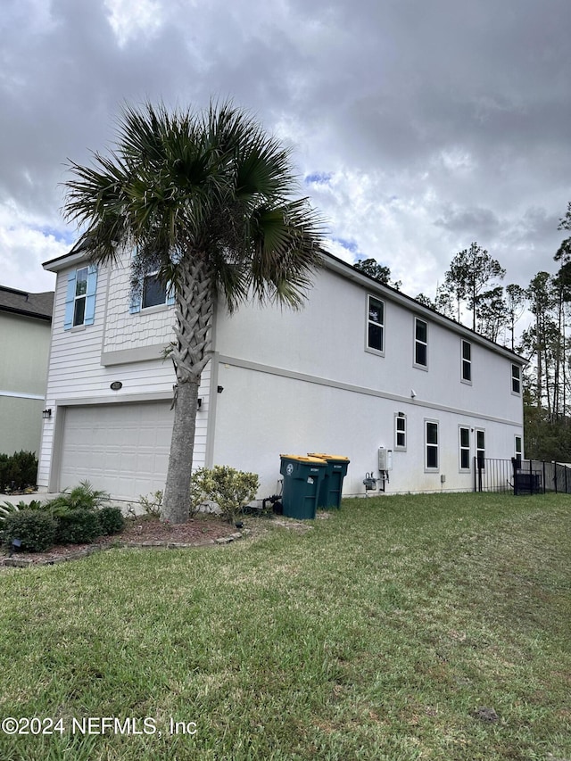 view of home's exterior featuring a garage and a lawn