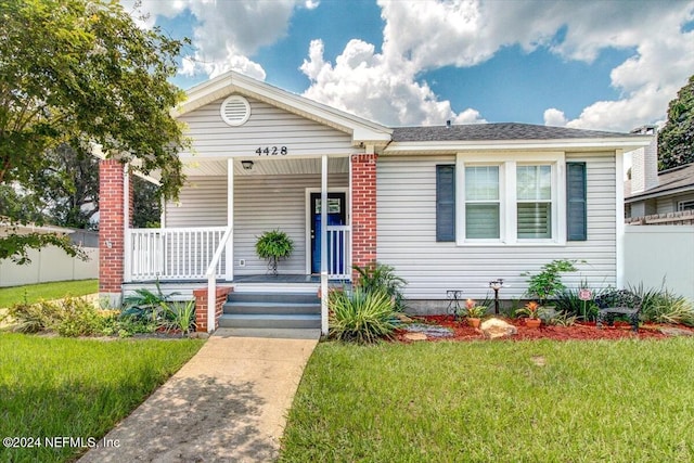 view of front of home with a porch and a front yard