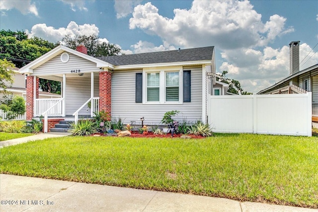 view of front of home with covered porch and a front yard