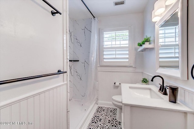 bathroom featuring toilet, vanity, and a shower with shower curtain