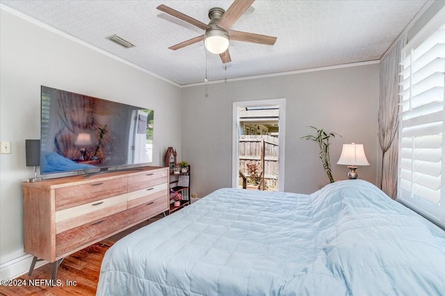 bedroom with ceiling fan, a textured ceiling, and multiple windows