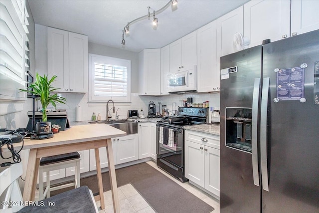 kitchen with white cabinets, sink, decorative backsplash, black / electric stove, and stainless steel fridge with ice dispenser