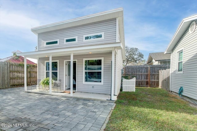 view of front of house featuring a patio and a front lawn