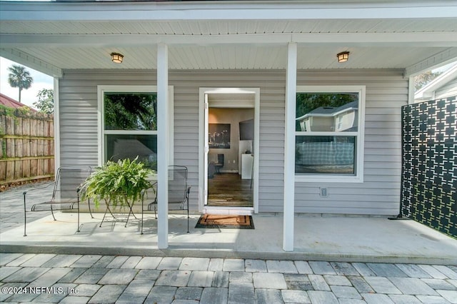 property entrance featuring a porch and a patio