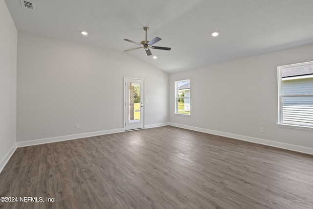 unfurnished room with a textured ceiling, ceiling fan, dark hardwood / wood-style floors, and vaulted ceiling