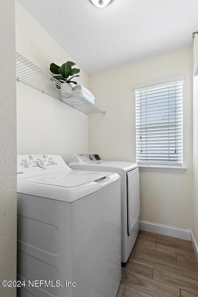 clothes washing area featuring hardwood / wood-style floors and washer and dryer