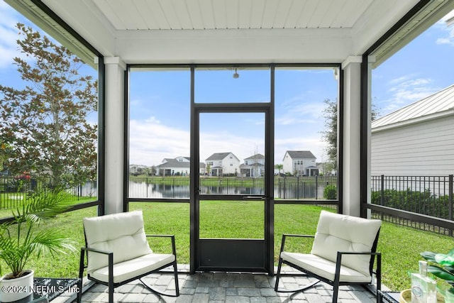 sunroom / solarium featuring a healthy amount of sunlight, a water view, and wood ceiling