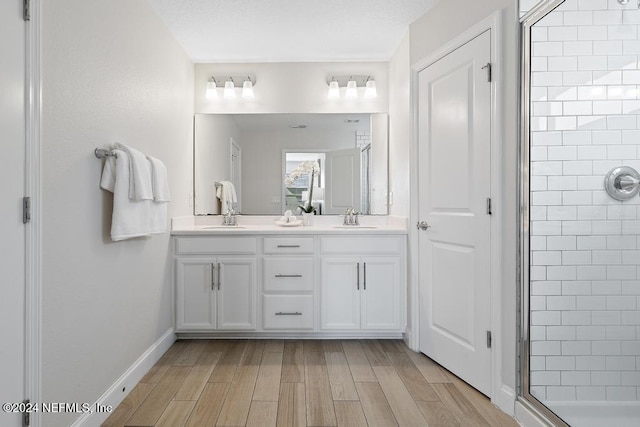 bathroom with vanity, wood-type flooring, and a shower with door