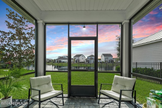 sunroom / solarium featuring a water view and a wealth of natural light