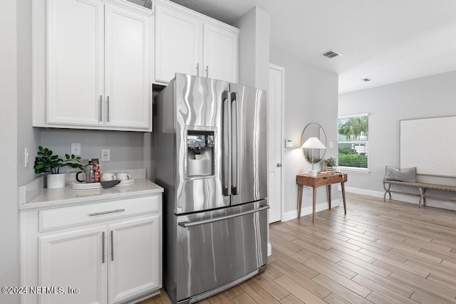 kitchen featuring white cabinetry, stainless steel refrigerator with ice dispenser, and light wood-type flooring