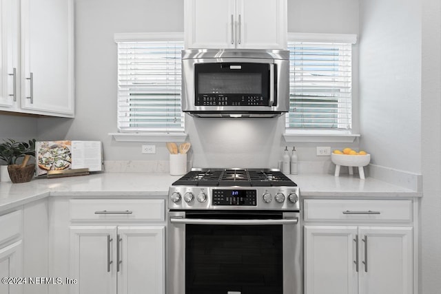 kitchen featuring light stone counters, white cabinetry, and appliances with stainless steel finishes