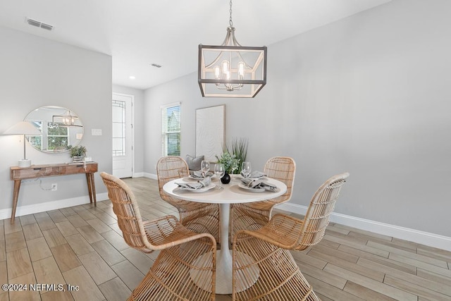 dining room featuring light hardwood / wood-style floors, a wealth of natural light, and a notable chandelier