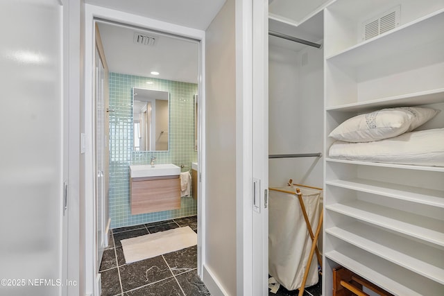 bathroom with vanity and tile walls