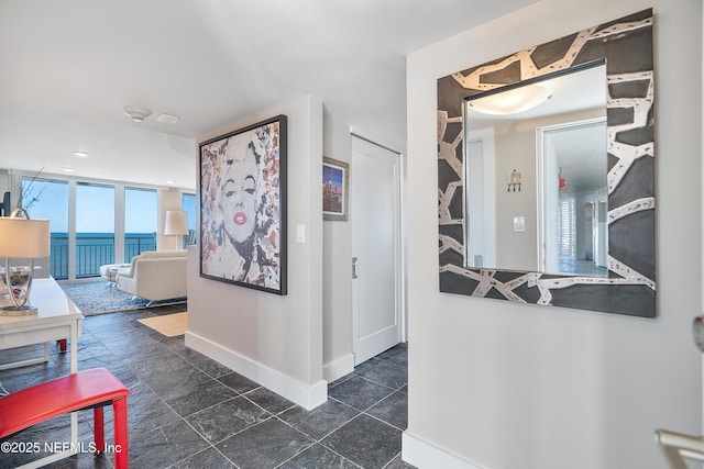 hallway featuring floor to ceiling windows and a water view