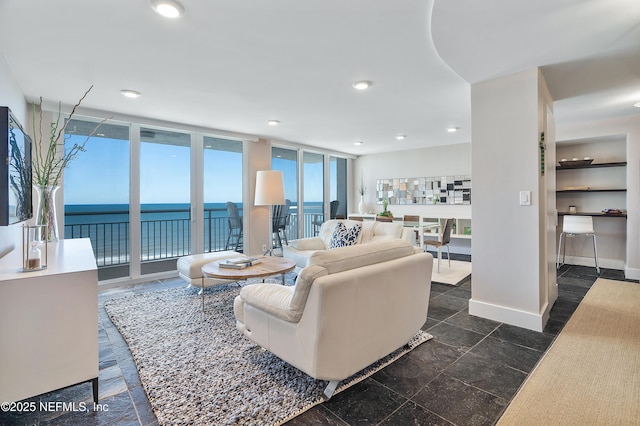 living room featuring expansive windows and a water view