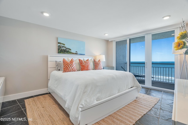 bedroom with access to exterior and a water view