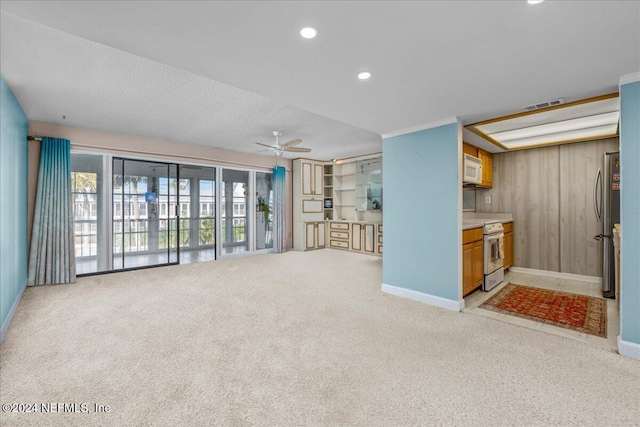 unfurnished living room featuring a textured ceiling, light colored carpet, and ceiling fan