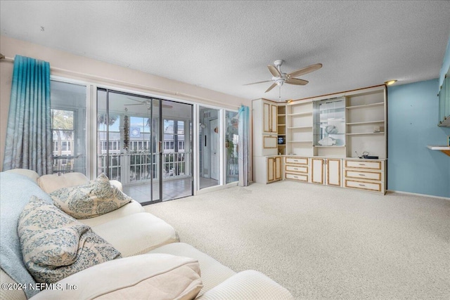 living room with carpet, a textured ceiling, and ceiling fan