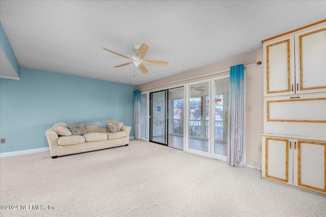 carpeted living room with ceiling fan and a textured ceiling