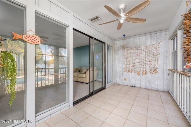 tiled spare room featuring ceiling fan and ornamental molding