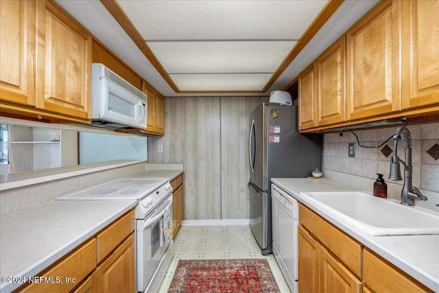 kitchen featuring tasteful backsplash, sink, and white appliances